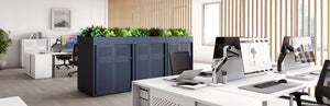 Bisley Glide Cupboard With Two Door Perforated Front Unit In White Finish With Indoor Plant And Desk In Office Setting