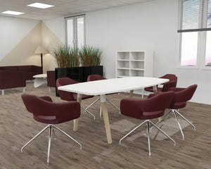 Buronomic Dialogue Barrel Meeting Table With Wooden Trapezium Legs In White Solid Wood Finish With Maroon Armchair And White Bookshelves In Meeting Room Setting