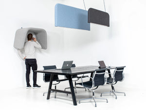 BuzziCocoon Upholstered Acoustic Desk Divider in Grey Finish with Table and Armchair in Office Setting