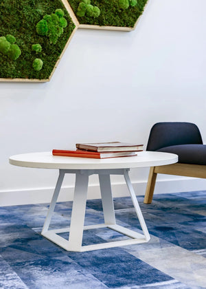 H2 Round Low Coffee Table in White with Black Armchair in Lounge Setting