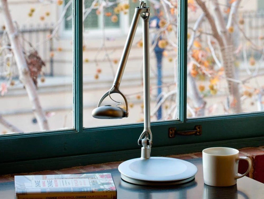 Humanscale Ergonomic And Dimmable Element 790 Desk Light 6 In Silver On Table With Book