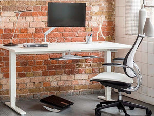 Humanscale Float Standing Office Desk For Office Or Home Areas 6 In White With Foot Rocker And White Chair In Office