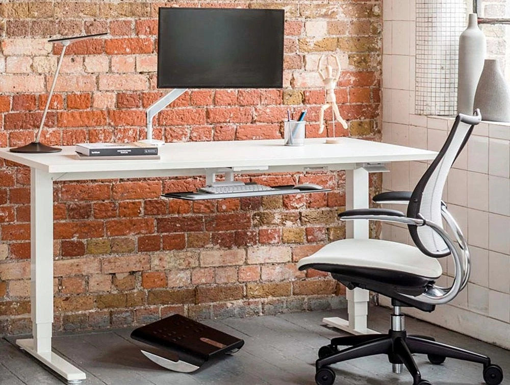 Humanscale Float Standing Office Desk For Office Or Home Areas 6 In White With Foot Rocker And White Chair In Office