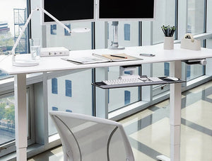 Humanscale Float Standing Office Desk For Office Or Home Areas 9 In White With White Desk Lamp And Dual Monitor