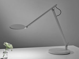 Humanscale Nova Adjustable Desk Light With Charging Desktop Base 6 In Gray On White Table With Plant