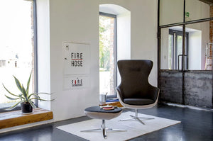 Loop Upholstered Lounge Armchair In Two Toned Finish With Upholstered Footrest And Black Plant Pot In Breakout Setting