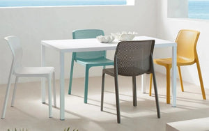 Nardi Bit Stackable Chair in Different Colors with White Rectangular Table Overlooking The Ocean