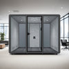 Silentium 6 Person Meeting Pod Slate Grey with Black Armchair and Wooden Coffee Table in Modern Office Setting