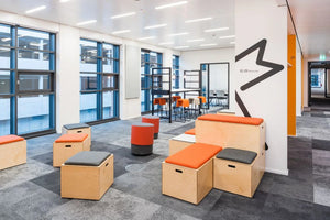 Spacestor Modular Zoning Wooden Bleacher System in Grey and Orange Top with Orange Pouffe and Orange High Stool in Leisure Area