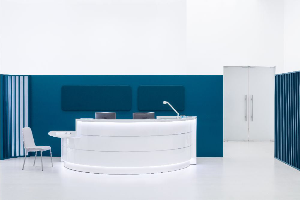 Valde Modular Reception Desk with with Visitor Chair and Table Lamp in Reception Setting